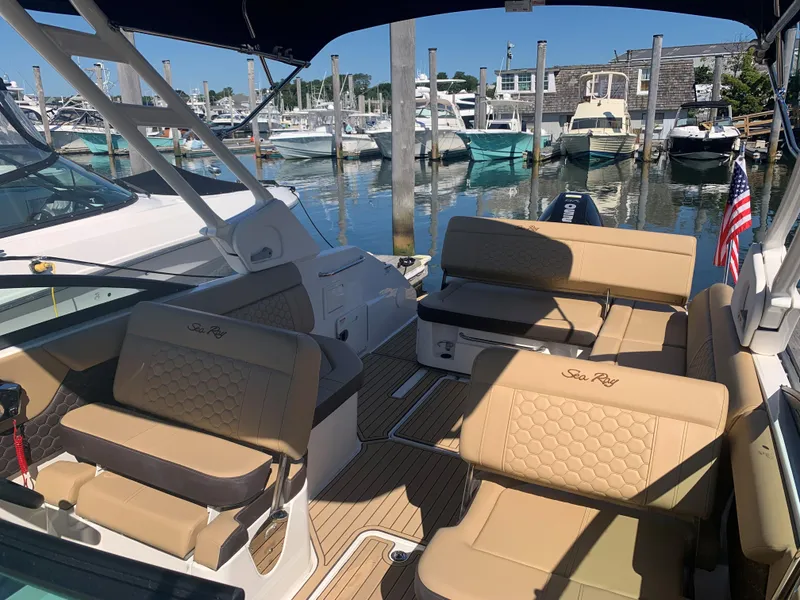 Slide: The Image of 2024 Sea Ray SDX 250 Outboard boat interior with tan seating at marina. - 20
