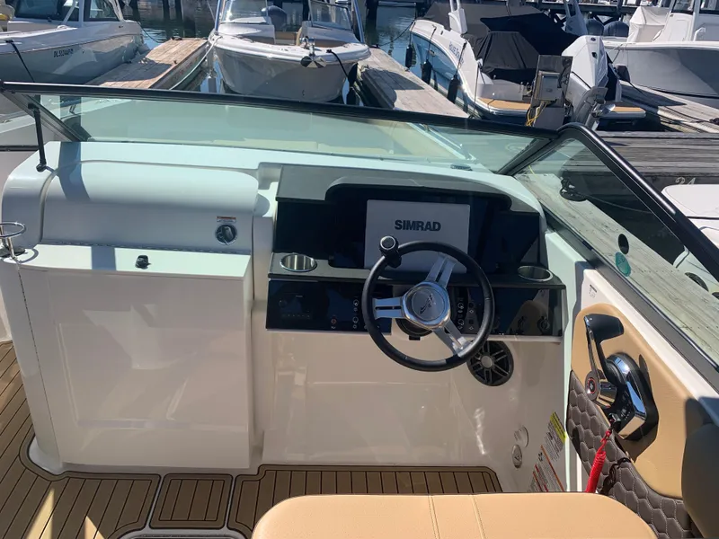 Slide: The Image of 2024 Sea Ray SDX 250 Outboard helm with Simrad display, docked at marina. - 21