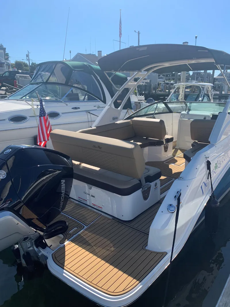 Slide: The Image of 2024 Sea Ray SDX 250 Outboard boat with spacious seating and sleek design at a marina. - 4