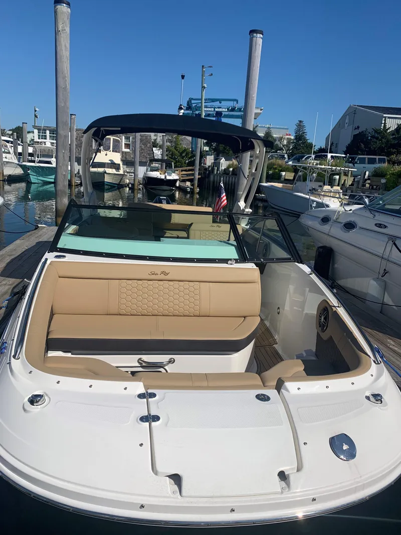 Slide: The Image of 2024 Sea Ray SDX 250 Outboard boat docked at marina, featuring tan seating. - 6