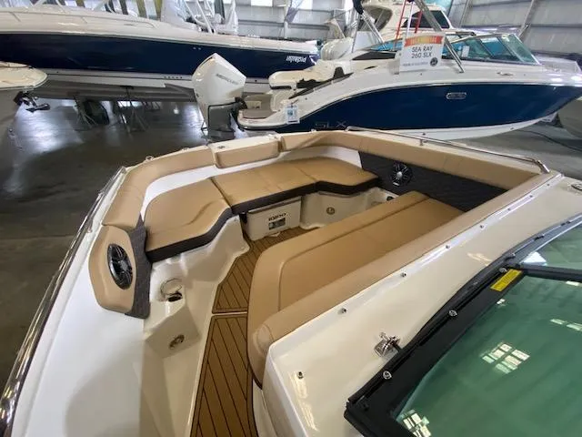 Slide: The Image of 2024 Sea Ray SDX 250 Outboard boat interior with tan seating in showroom. - 9