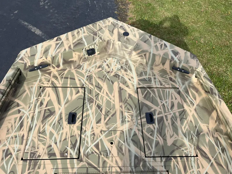 Slide: The Image of 2025 Lowe Roughneck 1860 Tunnel Jet boat with camouflage pattern on deck. - 10