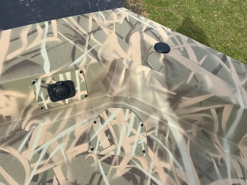 Slide: The Image of 2025 Lowe Roughneck 1860 Tunnel Jet boat with camouflage pattern, top view. - 12