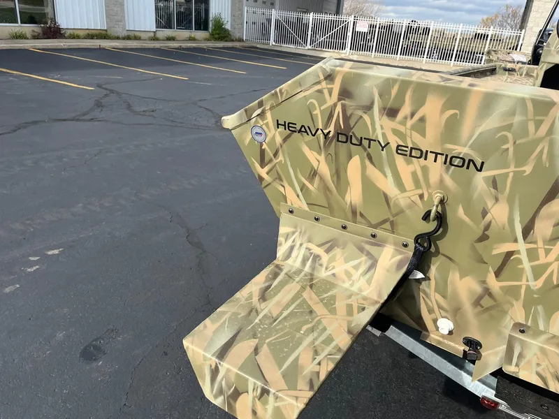 Slide: The Image of 2025 Lowe Roughneck 1860 Tunnel Jet, Heavy Duty Edition, camo design in parking lot. - 19