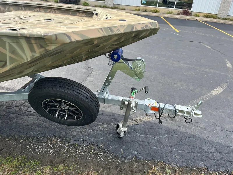Slide: The Image of 2025 Lowe Roughneck 1860 Tunnel Jet boat on trailer, parked on asphalt. - 21