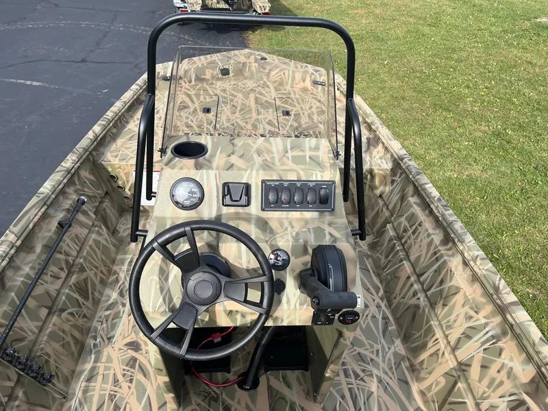 Slide: The Image of 2025 Lowe Roughneck 1860 Tunnel Jet boat with camo interior and steering console. - 6