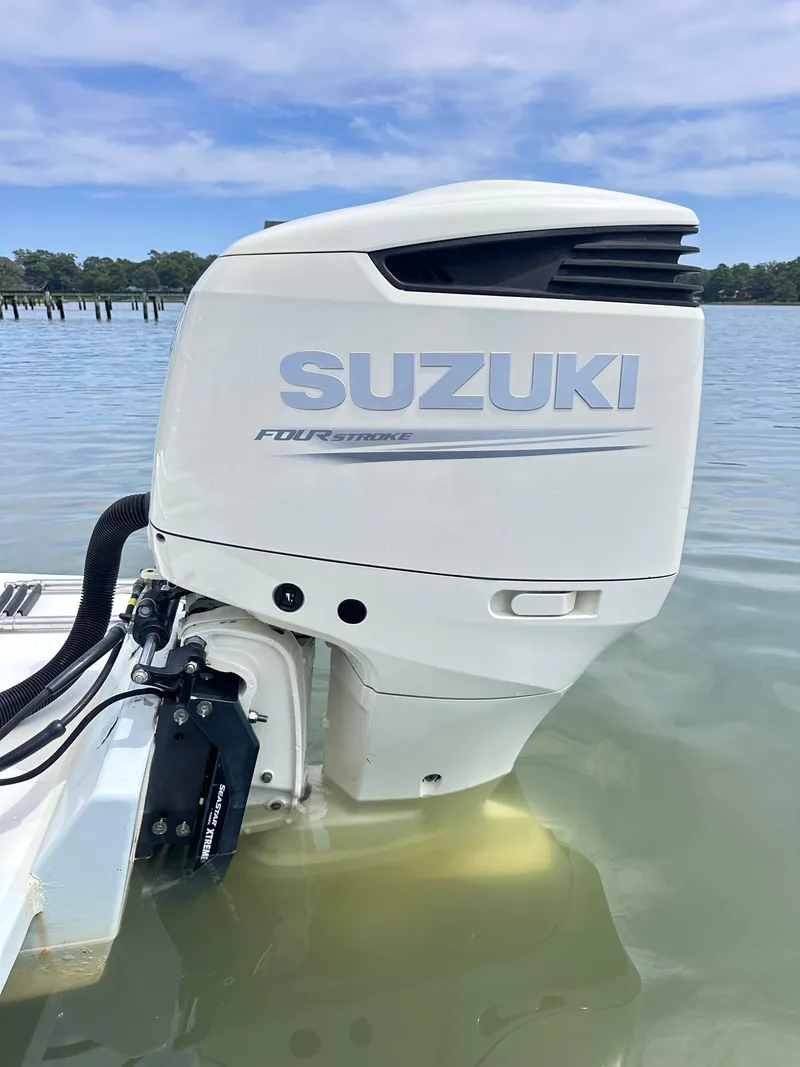 Slide: The Image of Suzuki outboard motor on 1995 Mako 221 B Classic Center Console in water. - 11