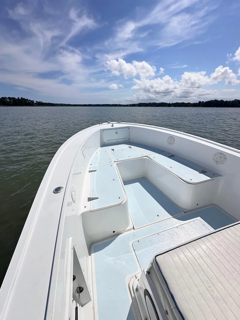 Slide: The Image of 1995 Mako 221 B Classic Center Console boat on calm water under blue sky. - 13