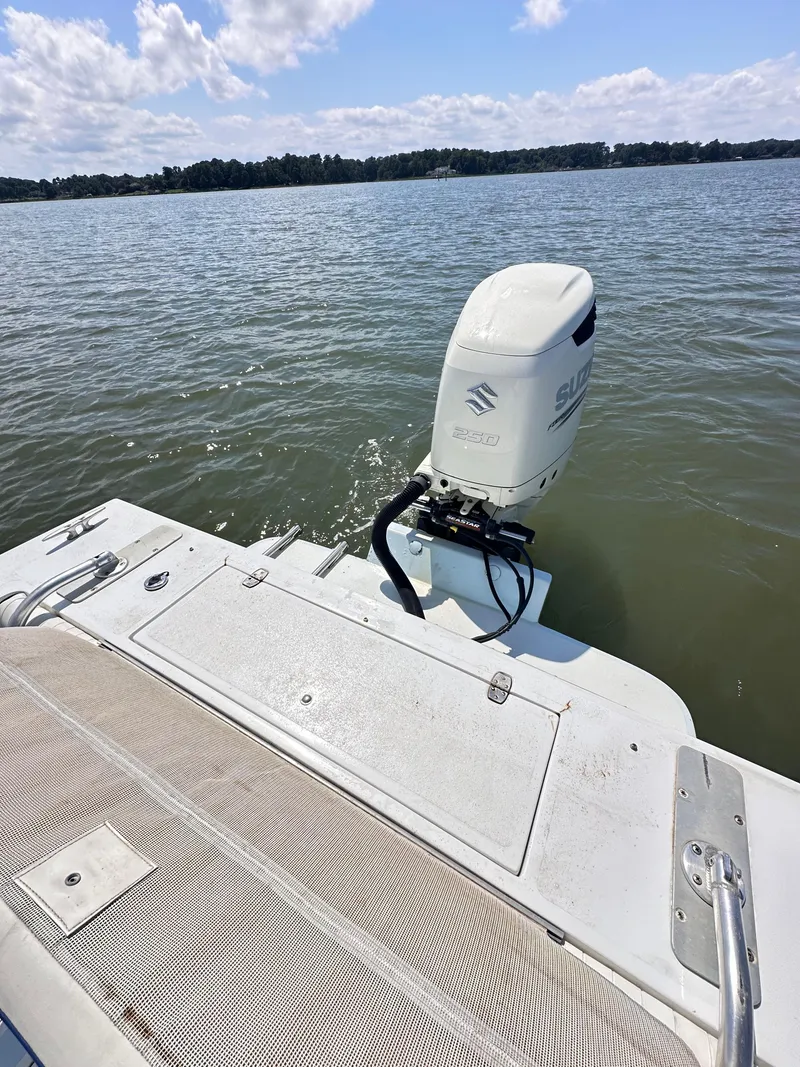 Slide: The Image of 1995 Mako 221 B Classic Center Console boat with Suzuki outboard motor on a calm lake. - 18