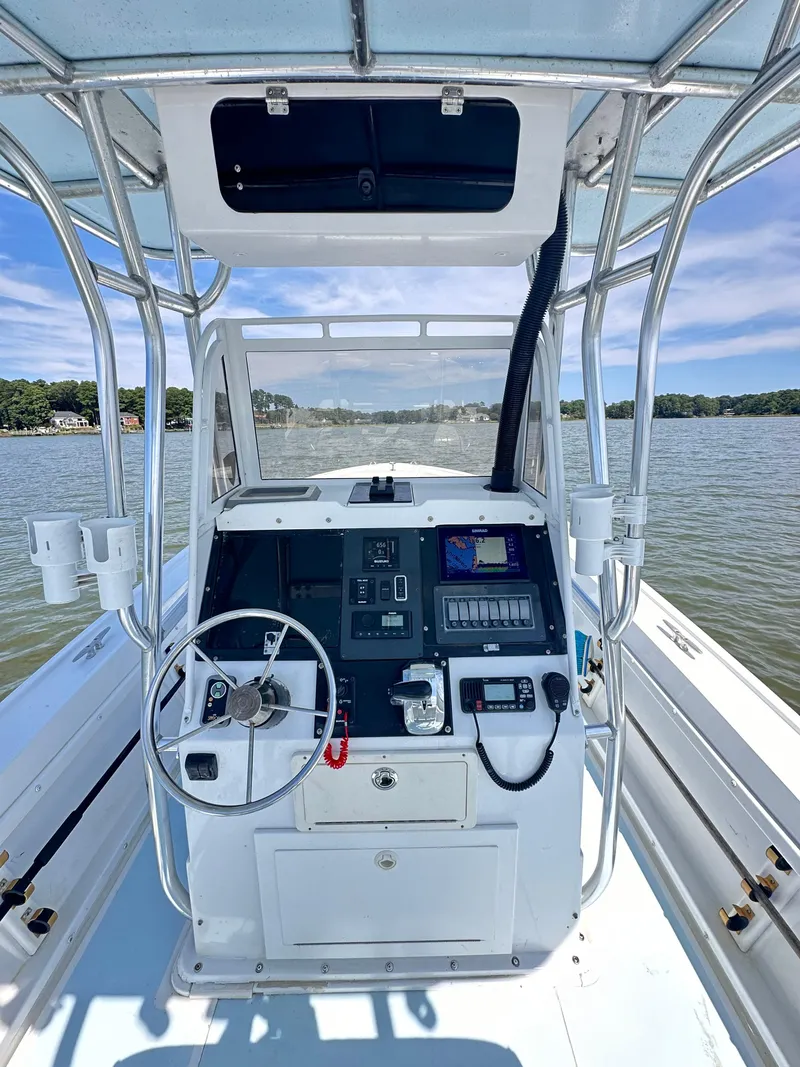 Slide: The Image of 1995 Mako 221 B Classic Center Console boat on a lake, featuring a detailed helm. - 3