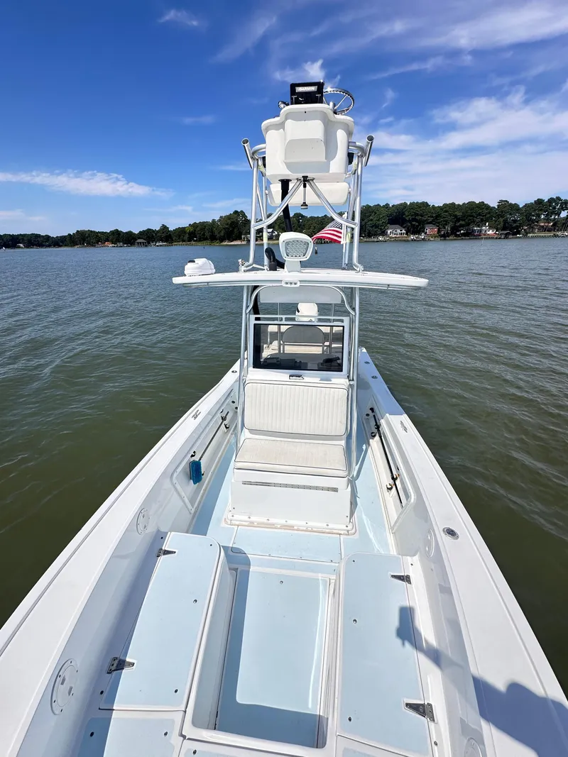 Slide: The Image of 1995 Mako 221 B Classic Center Console boat on calm water under blue sky. - 4