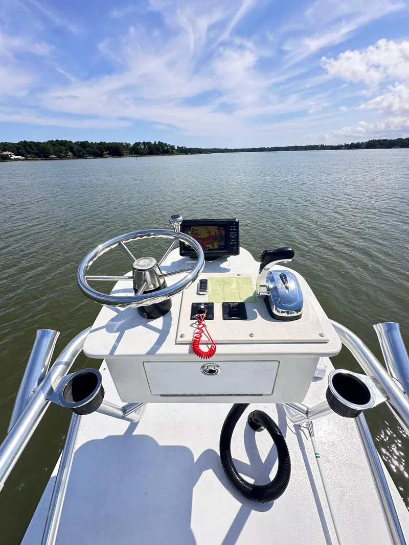 Slide: The Image of 1995 Mako 221 B Classic Center Console boat on calm water under blue sky. - 5