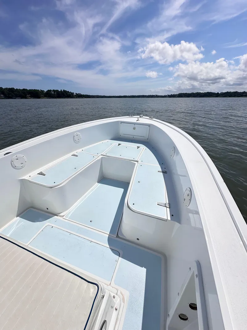 Slide: The Image of 1995 Mako 221 B Classic Center Console boat on calm water under blue sky. - 6