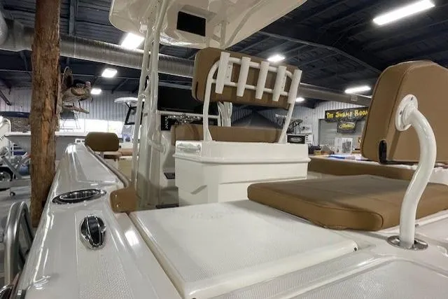 Slide: The Image of 2025 Skeeter SX2550 boat interior with tan seating and rod holders in a showroom. - 10