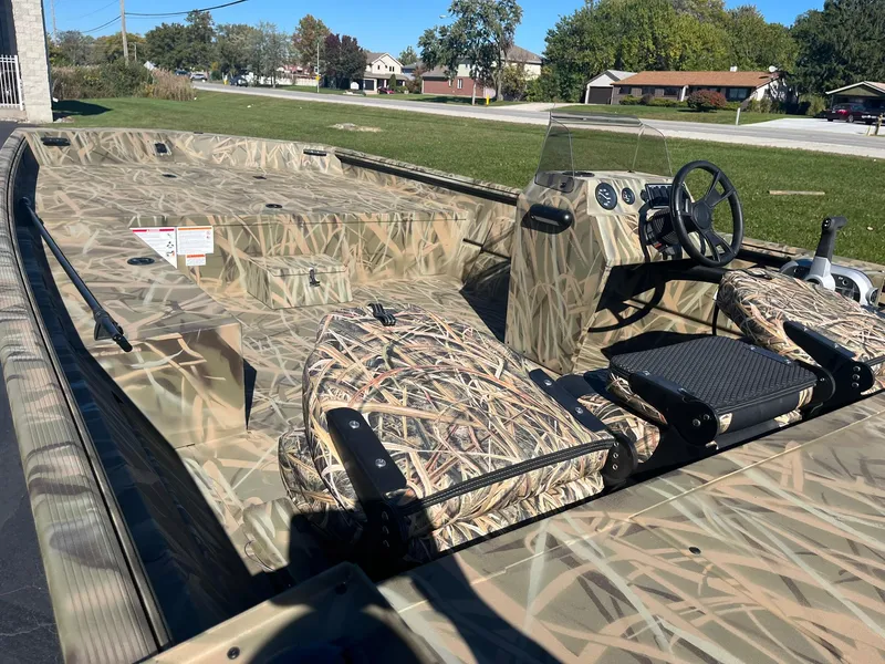 Slide: The Image of 2025 Lowe Roughneck 2070 SC boat with camouflage design, parked outdoors. - 10