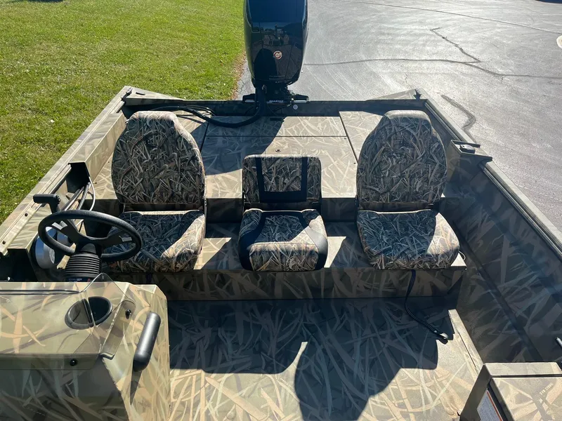 Slide: The Image of 2025 Lowe Roughneck 2070 SC boat interior with camo seats and steering console. - 12