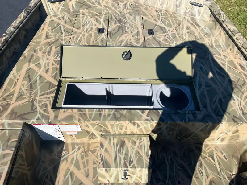 Slide: The Image of 2025 Lowe Roughneck 2070 SC boat with camouflage design and storage compartments. - 14