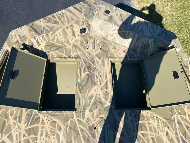 Slide: The Image of 2025 Lowe Roughneck 2070 SC boat with open storage compartments, camo design. - 15