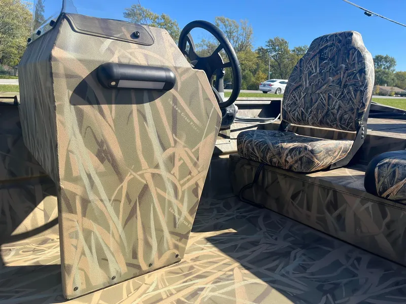 Slide: The Image of 2025 Lowe Roughneck 2070 SC boat interior with camouflage design and steering console. - 20