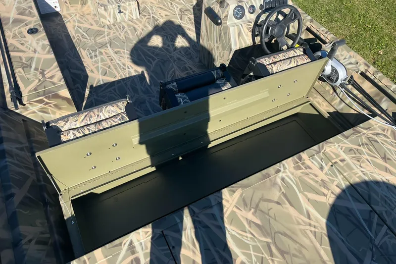 Slide: The Image of 2025 Lowe Roughneck 2070 SC boat interior with camouflage design and steering console. - 21