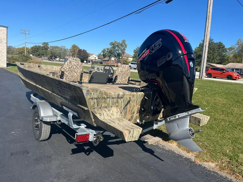 Slide: The Image of 2025 Lowe Roughneck 2070 SC boat with camo design and powerful outboard motor. - 4