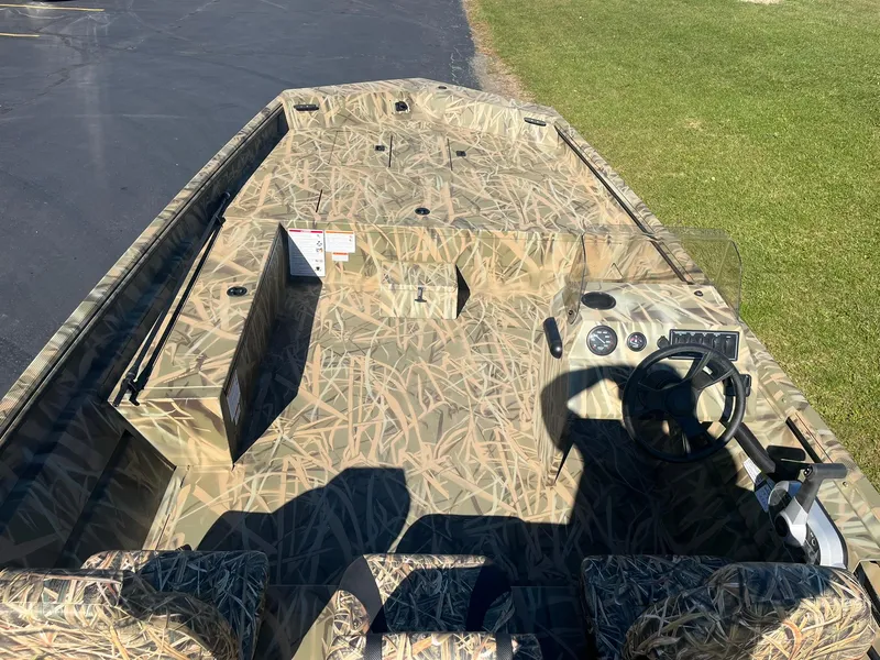 Slide: The Image of 2025 Lowe Roughneck 2070 SC boat with camouflage design, steering console, and seating. - 8