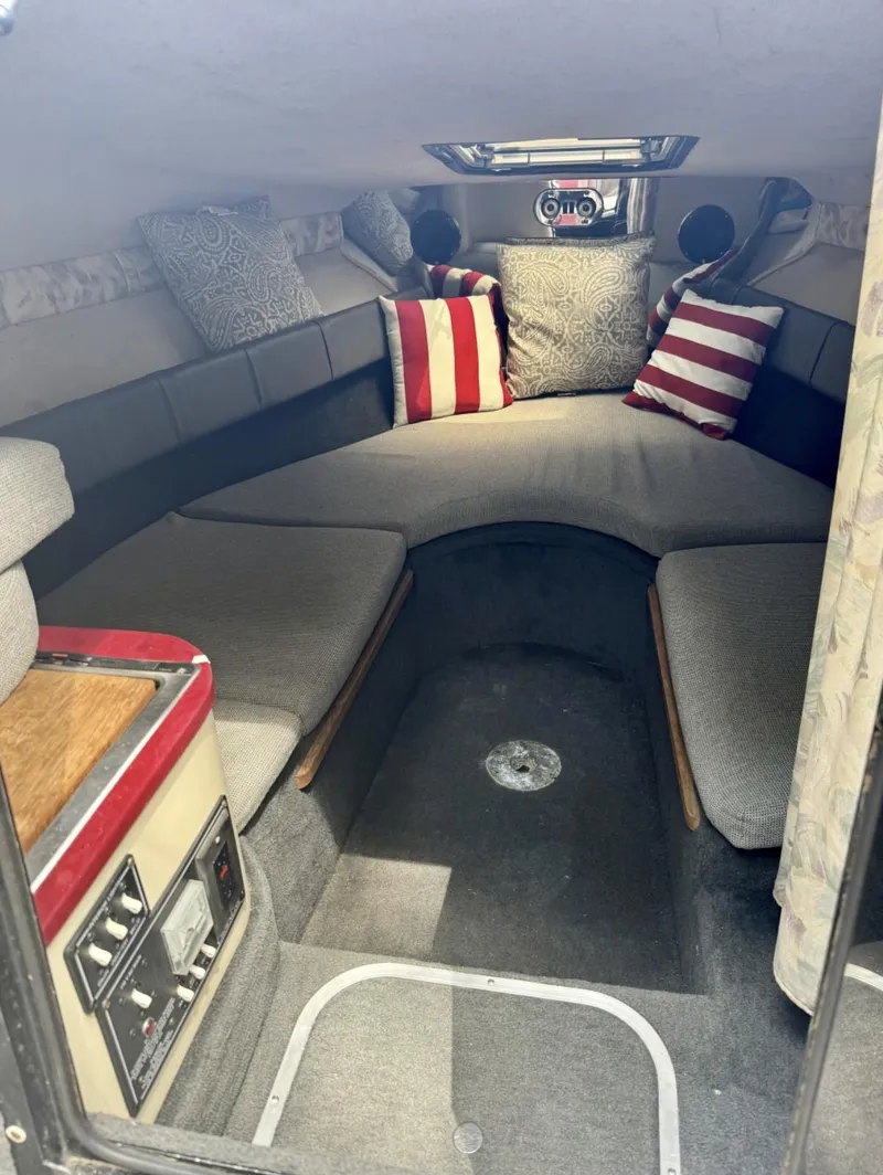Slide: The Image of Interior of a 1992 Crownline 210 CCR boat with cozy seating and striped pillows. - 5