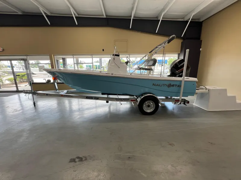 Slide: The Image of 2025 NauticStar 194 Bay boat on trailer in showroom. - 0