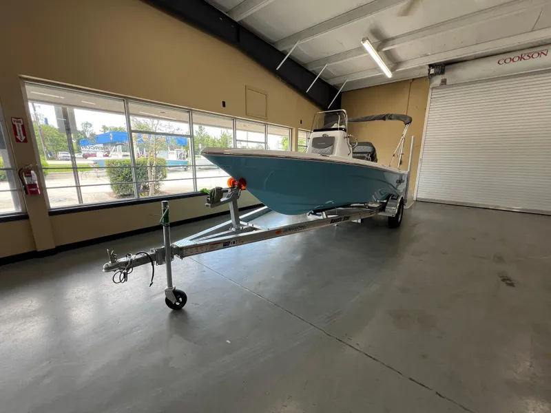Slide: The Image of 2025 NauticStar 194 Bay boat on trailer in indoor showroom. - 1