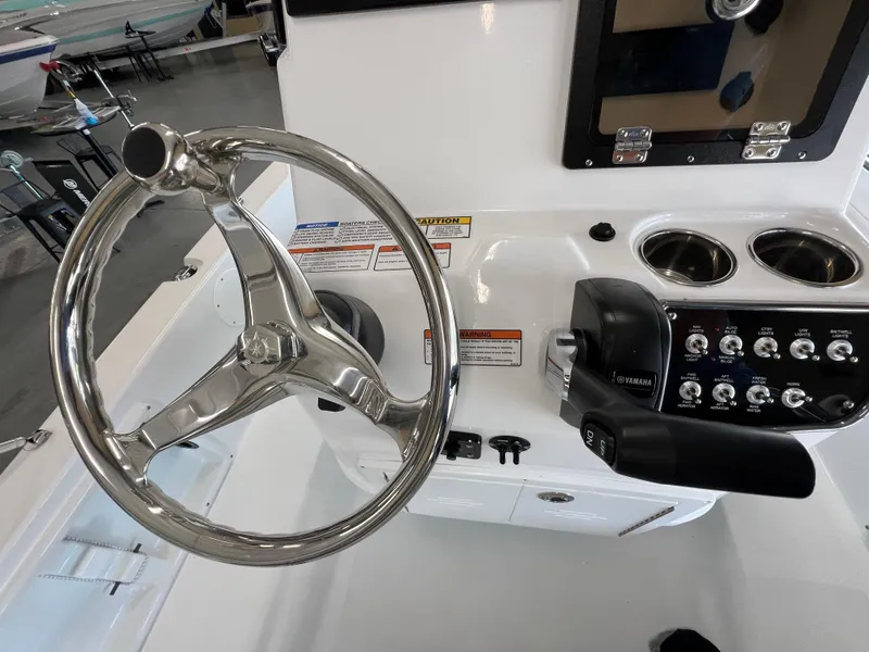 Slide: The Image of 2025 NauticStar 194 Bay boat steering console with controls and cup holders. - 15