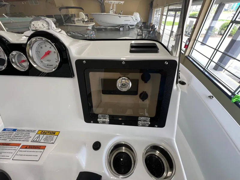 Slide: The Image of 2025 NauticStar 194 Bay boat dashboard with gauges and storage compartment. - 17