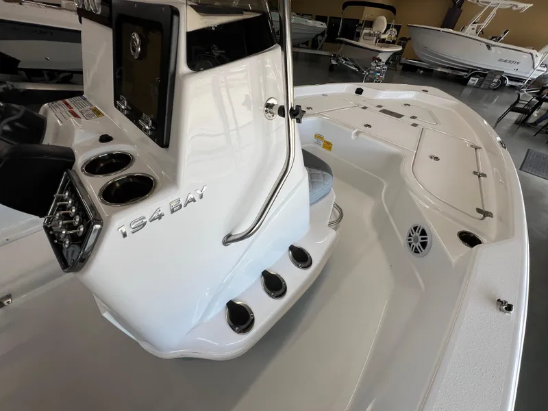Slide: The Image of 2025 NauticStar 194 Bay boat interior, featuring console and seating area in showroom. - 19