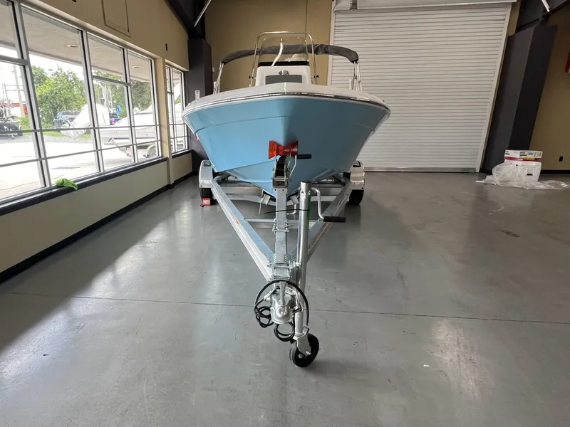 Slide: The Image of 2025 NauticStar 194 Bay boat on trailer in showroom. - 2