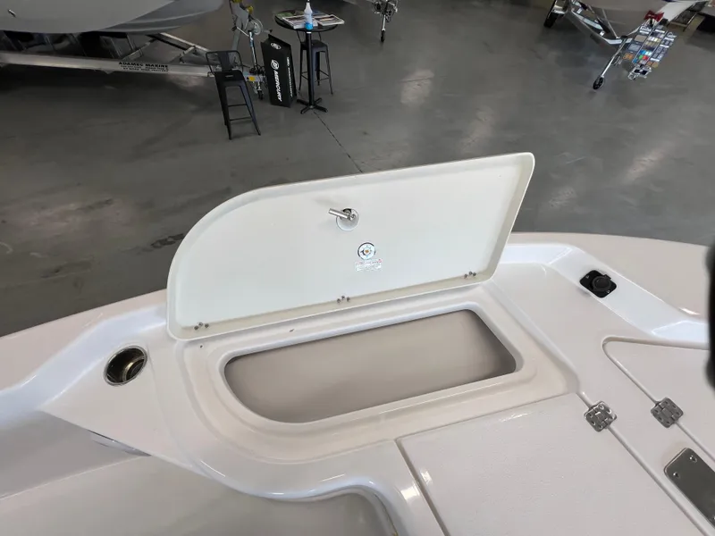 Slide: The Image of 2025 NauticStar 194 Bay boat storage compartment open in showroom. - 25
