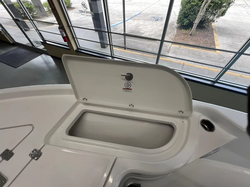 Slide: The Image of 2025 NauticStar 194 Bay boat storage compartment open in showroom. - 27