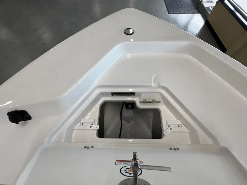 Slide: The Image of 2025 NauticStar 194 Bay boat bow with storage compartment and clean white finish. - 28