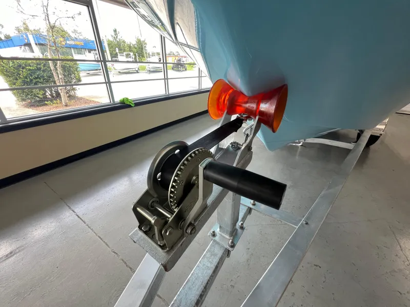 Slide: The Image of 2025 NauticStar 194 Bay boat on trailer with winch and roller in showroom. - 6
