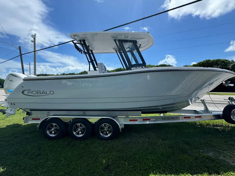 Slide: The Image of 2025 Robalo R270 Center Console boat on a trailer, under a clear blue sky. - 3