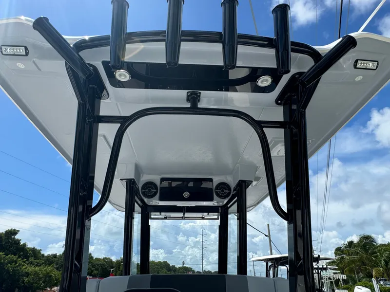 Slide: The Image of 2025 Robalo R270 Center Console boat, featuring a sleek T-top design against a clear blue sky. - 9