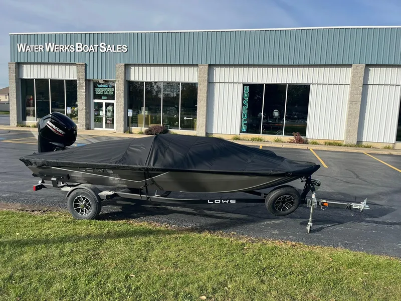 Slide: The Image of 2025 Lowe Stinger 175C boat covered, parked outside Water Werks Boat Sales. - 19