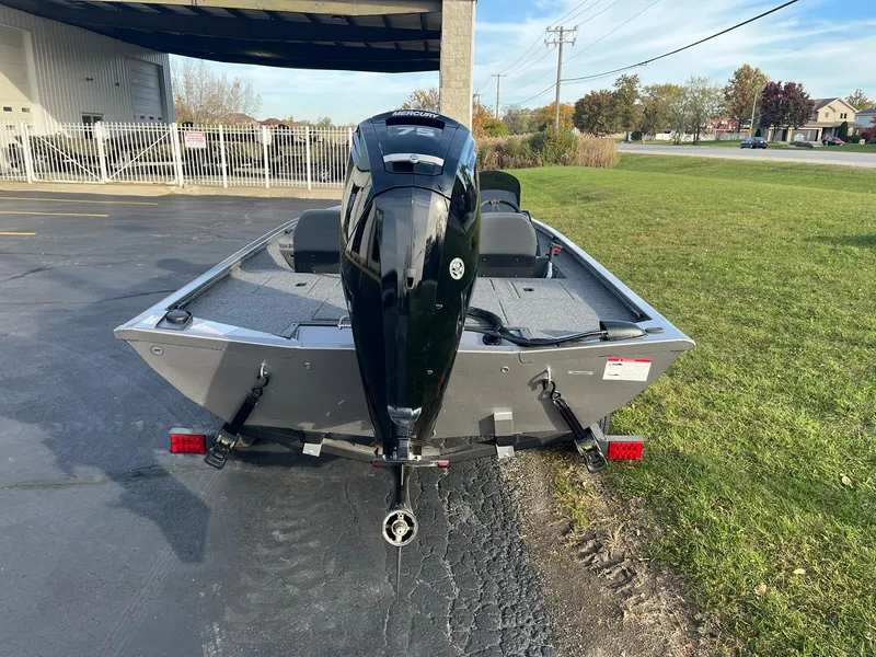Slide: The Image of 2025 Lowe Stinger 175C boat with outboard motor, parked on pavement. - 3