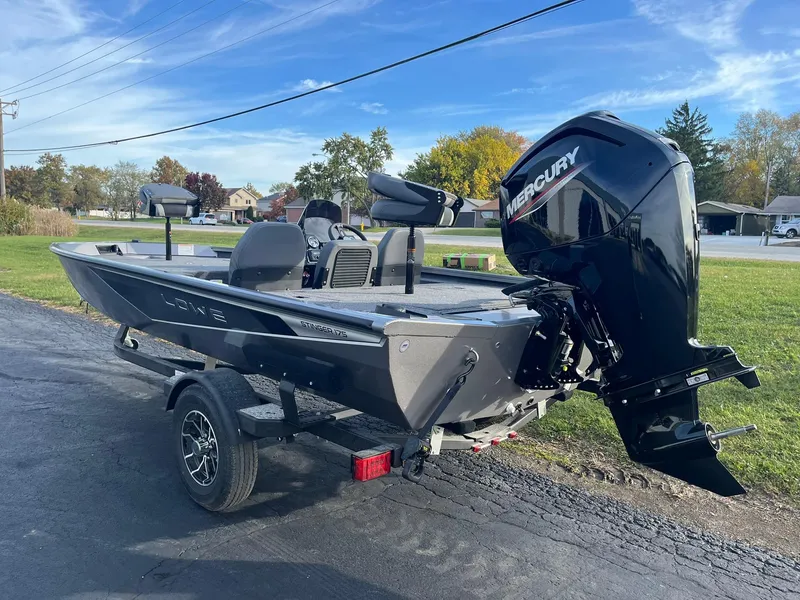 Slide: The Image of 2025 Lowe Stinger 175C boat with Mercury engine on a trailer, parked outdoors. - 4