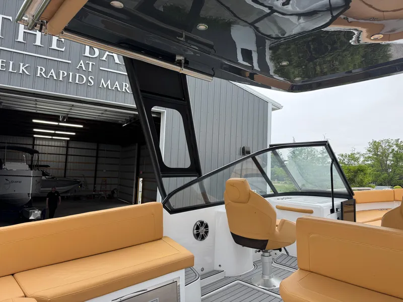 Slide: The Image of 2025 Iguana Bow Rider boat with tan seating, docked near a marina building. - 15