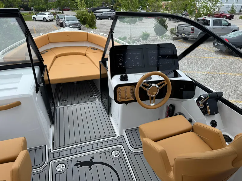 Slide: The Image of 2025 Iguana Bow Rider boat interior with tan seating, modern dashboard, and sleek design. - 16