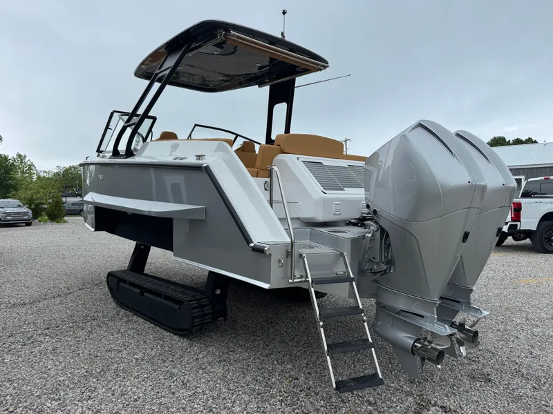 Slide: The Image of 2025 Iguana Bow Rider boat with dual outboard motors and retractable tracks on gravel. - 5