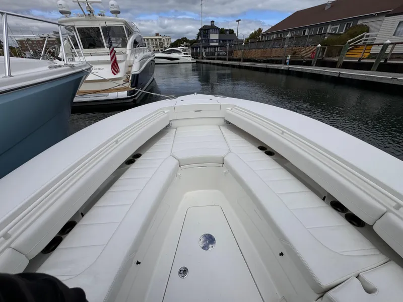 Slide: The Image of 2018 Regulator 28 boat docked in marina, featuring spacious seating and sleek design. - 10