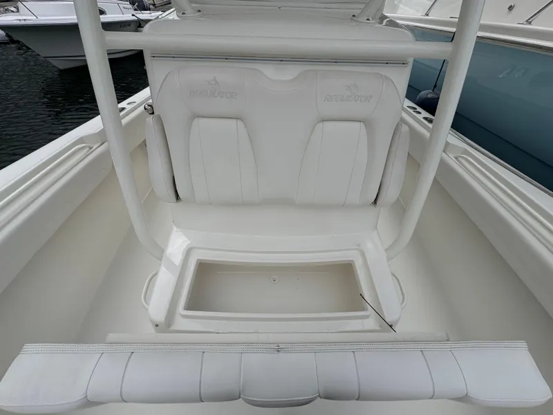 Slide: The Image of 2018 Regulator 28 boat interior with white seating and storage compartment. - 14