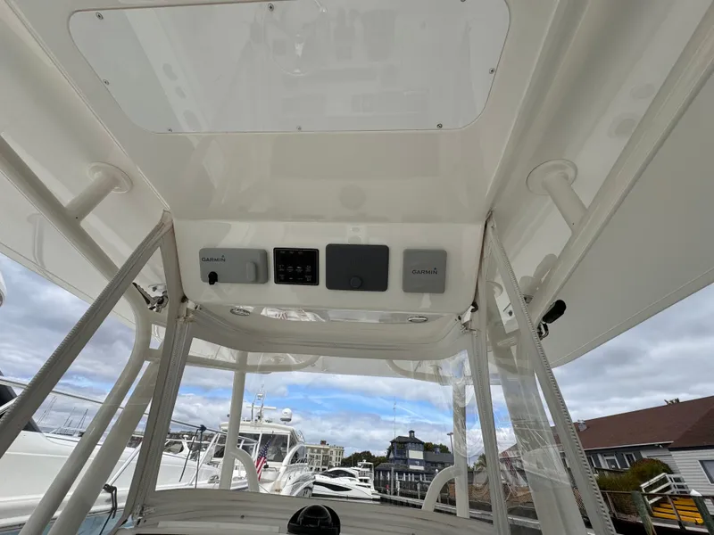 Slide: The Image of 2018 Regulator 28 boat console with electronics, docked under a cloudy sky. - 17