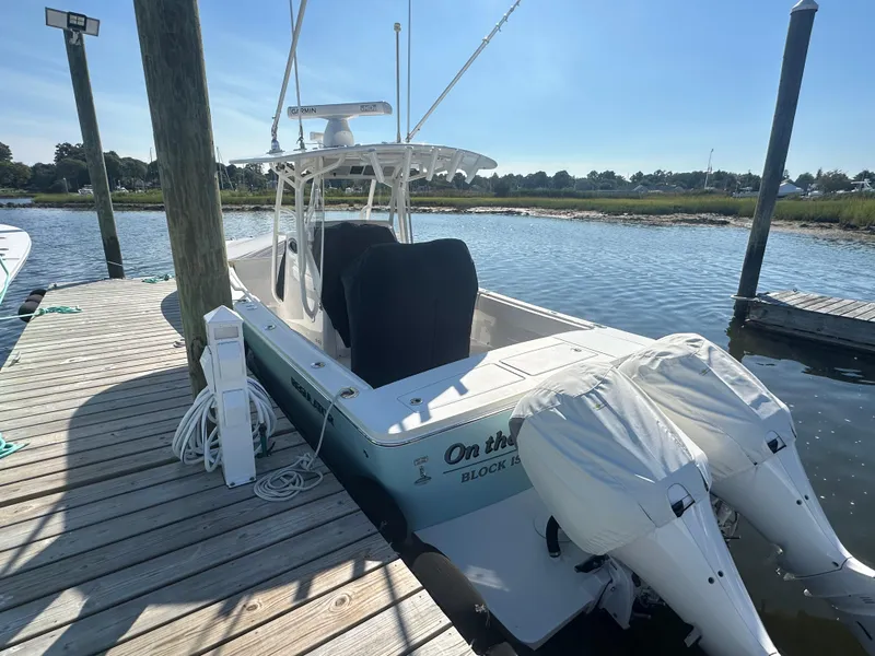 Slide: The Image of 2018 Regulator 28 boat docked with twin engines, sunny day, calm water. - 2