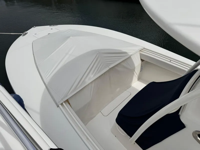 Slide: The Image of 2018 Regulator 28 boat with white canopy and navy seating. - 8